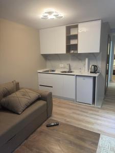 a living room with a couch and a kitchen at Premium Rooms in Struga