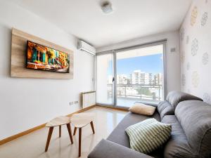 ein Wohnzimmer mit Sofa und großem Fenster in der Unterkunft AC Suites in Puerto Madryn