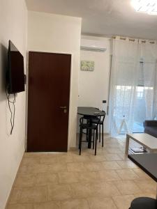 a door to a living room with a table and a television at Faraboni Apartments in Novara
