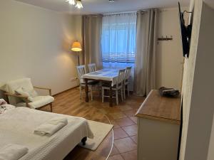 a living room with a table and chairs and a kitchen at Agroturystyka Pod Kogutkiem in Czysta