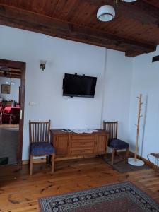 a living room with two chairs and a television on a wall at Agroturystyka Folwark in Leszno