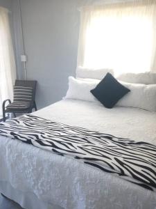 a bed with a black and white sheets and a window at JJM Accommodation in Keetmanshoop
