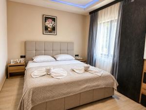 a bedroom with a large bed with bows on it at Къща за гости ЕМ Парадайс in Tserova Koriya +29 photos