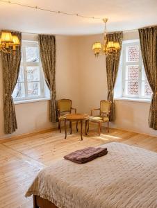 a bedroom with a bed and a table and chairs at Arāja apartamenti in Kuldīga