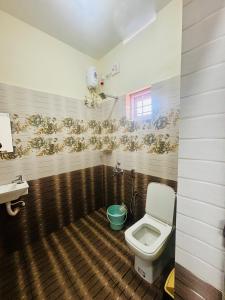 a bathroom with a toilet and a sink at Babuloos Homestay in Varkala