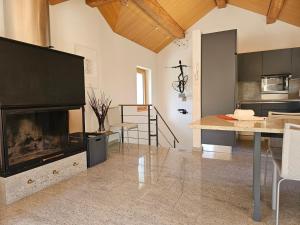 a living room with a fireplace and a table at Cà ai Camòss, DUPLEX deluxe - centro paese in San Bernardino