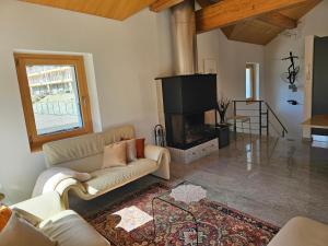 a living room with a couch and a fireplace at Cà ai Camòss, DUPLEX deluxe - centro paese in San Bernardino