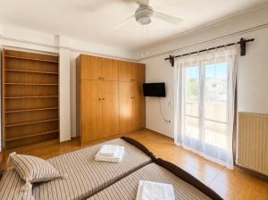 a bedroom with a bed and a large window at Casa di Ricci Paros in Dhragoulás