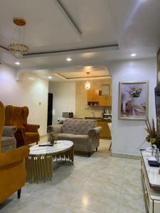 a living room with a couch and a table at Hollysee Hotel & Suites in Baruwa +5 photos