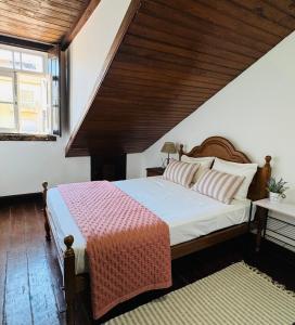 a bedroom with a large bed with a wooden ceiling at Oi Braga Hostel in Braga