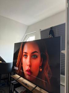 a tv screen with a picture of a woman at Gemütlicher Aufenthalt mit Netflix & perfekter Anbindung! in Elmshorn