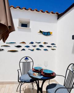 a table and chairs in front of a wall with fish decals at Frida Luxury B&B in Vietri sul Mare
