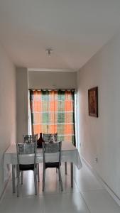 a dining room with a table and chairs and a window at Apartamento do Sol in Diamantina