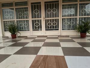 a checkered floor with two potted plants in front of doors at Suzie's Nest 2 in Lilongwe