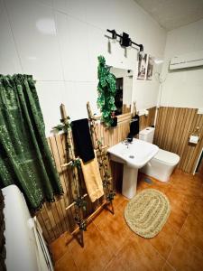 a bathroom with a white sink and a toilet at Love Home Ronquillo in El Ronquillo
