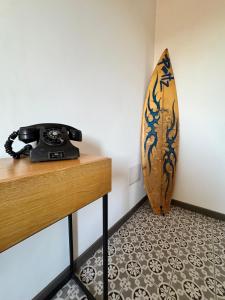 a phone sitting on a counter next to a surfboard at Tattoo Home in Martone +8 photos