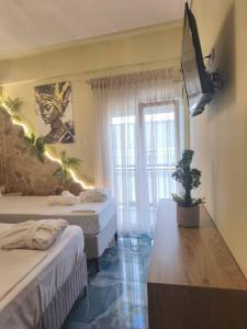 a room with two beds and a tv on the wall at Faros in Platamonas