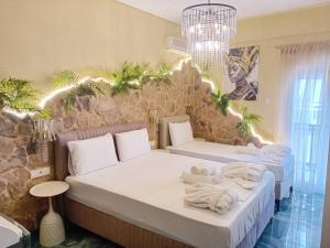 two beds in a room with towels on them at Faros in Platamonas