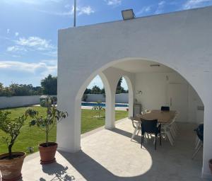 a patio with a table and chairs and an archway at San Calixto 8 in Sanlúcar de Barrameda