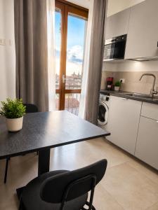 a kitchen with a table and chairs and a kitchen with a window at Suite Panoramica - Novara Centro in Novara