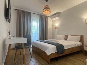 a bedroom with a bed and a table and a desk at AL MARE in Constanţa