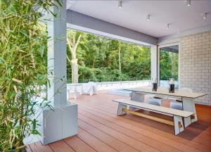 an open living room with a table and a bench at ThehiddenLakehouse Pool Sauna Whirlpool in Duisburg
