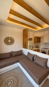 a living room with a couch and a kitchen at Pyrgianos Suites - Private Plunge Pool in Naxos Chora