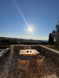 a wooden table and two chairs on a patio at Pyrgianos Suites - Private Plunge Pool in Naxos Chora