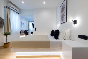 a white bedroom with a large bed in a room at RODAVGI APARTMENTS in Andros
