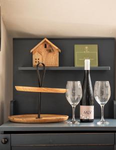 a bottle of wine and two glasses on a table at Enos Retreat Villas in Agios Nikolaos