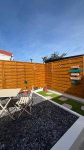 a patio with a table and chairs and a fence at La Parenthèse in Sangatte