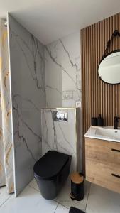 a bathroom with a black toilet and a sink at La Parenthèse in Sangatte +11 photos
