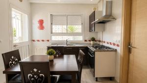 a kitchen with a table and a sink and a stove at Residence Golden Beach au bord de la mer in Bin Rhilouf