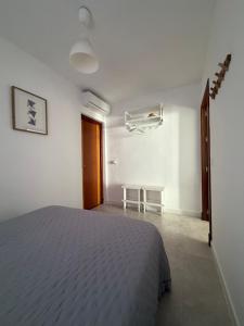 a bedroom with a bed in a white room at San Calixto 8 in Sanlúcar de Barrameda