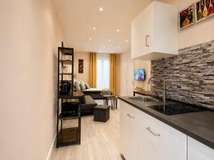 a kitchen with white cabinets and a living room at Subway Apartment in Koblenz