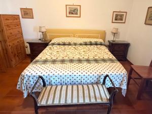 a bedroom with a bed with a bench in it at La Casetta di Serenella in Andali