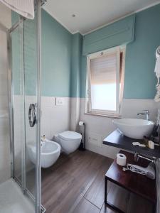ein Badezimmer mit zwei Waschbecken, Toilette und Dusche in der Unterkunft Levante in Trani