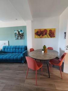 ein Wohnzimmer mit einem blauen Sofa und einem Tisch und Stühlen in der Unterkunft Levante in Trani + 52 Fotos