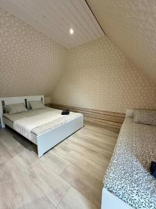 a bedroom with two beds and a wooden floor at Orjaku Sadamavaade in Orjaku
