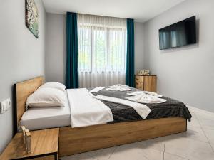 a bedroom with a large bed with a television on the wall at Къща за гости ЕМ Парадайс 2 in Tserova Koriya +37 photos