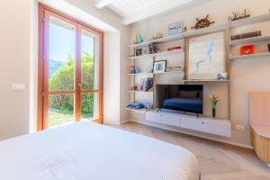 a bedroom with a bed and a tv and a window at Lakeside Garden Studio in Laglio