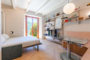 a bedroom with a bed and a desk in it at Lakeside Garden Studio in Laglio