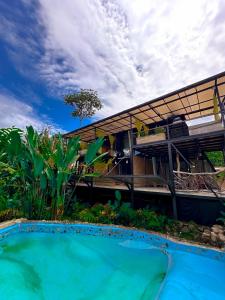 a house with a swimming pool in front of it at Suites Casa ColibrÍ in Mindo