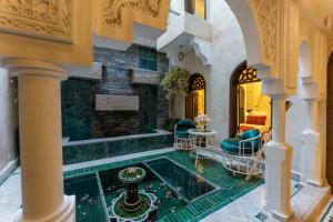 an indoor lobby with a pool in the middle of a building at Riad Secret Mahjouba in Marrakesh