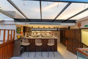 a kitchen with a bar with stools around it at Riad Secret Mahjouba in Marrakesh