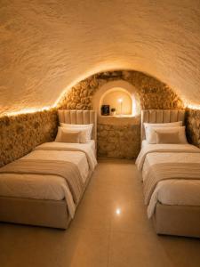 two beds in a room with a stone wall at וילת הארי בעתיקה in Safed +11 photos