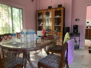 a dining room with a glass table and chairs at Mangifera Cabin in Kanchanrup in Kanchanpur
