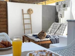 a living room with a couch and a table with a glass of orange juice at OLIA STUDIOS Olga studios in Faliraki