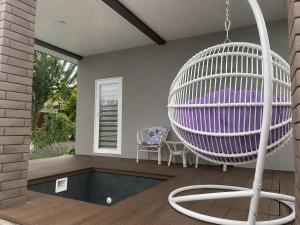 a porch with a purple chair and a swing at AmurRelaxCreative in Khmelnytskyi