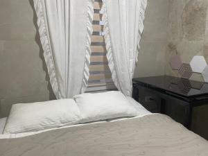 a bed with white pillows next to a desk at AmurRelaxCreative in Khmelnytskyi +33 photos